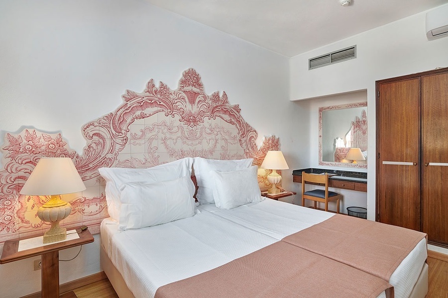 um quarto de hotel com uma cama e um espelho