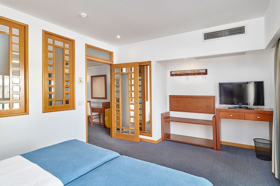 um quarto de hotel com duas camas e uma televisão