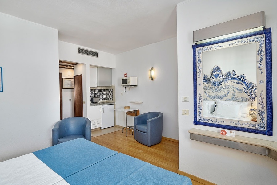 um quarto com uma cama azul e um espelho azul e branco