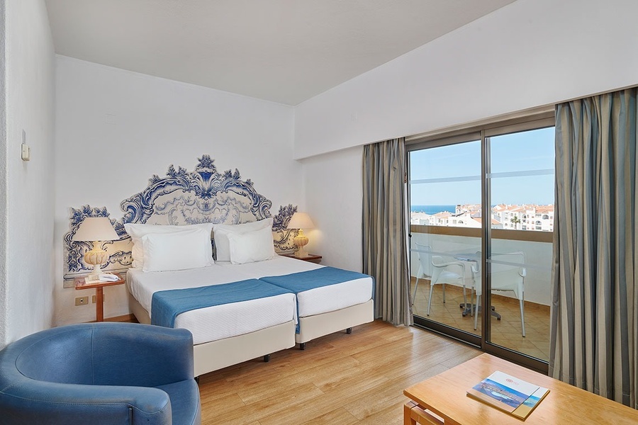 um quarto de hotel com uma cama e uma cadeira