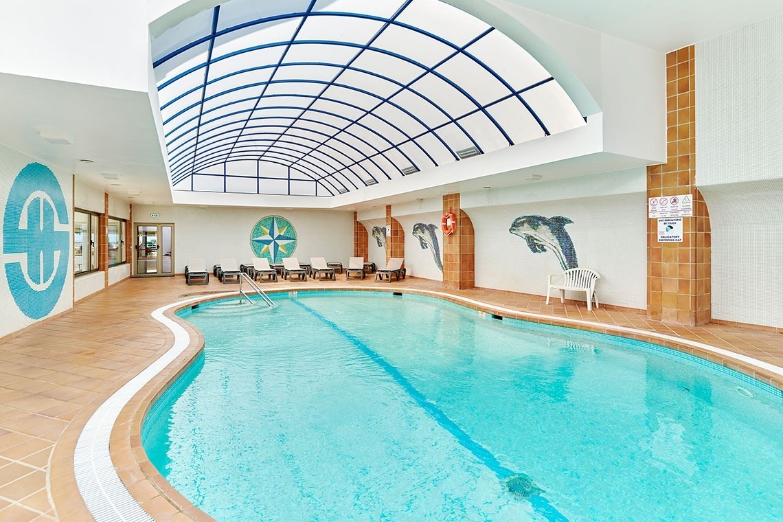 uma grande piscina coberta com um teto de vidro