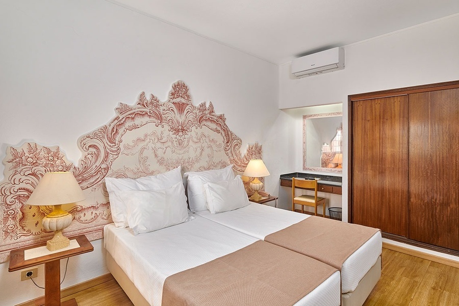 um quarto de hotel com duas camas e um armário