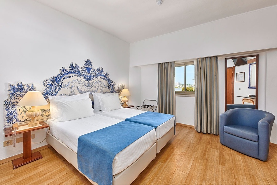 um quarto de hotel com duas camas e uma cadeira