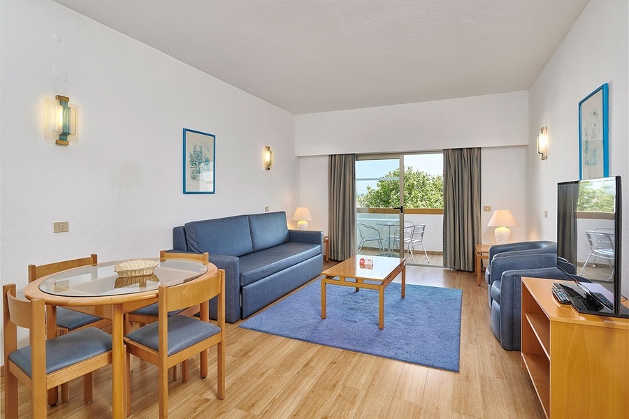 uma sala de estar com sofá azul mesa e cadeiras