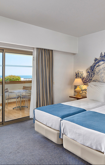 um quarto de hotel com duas camas e uma varanda