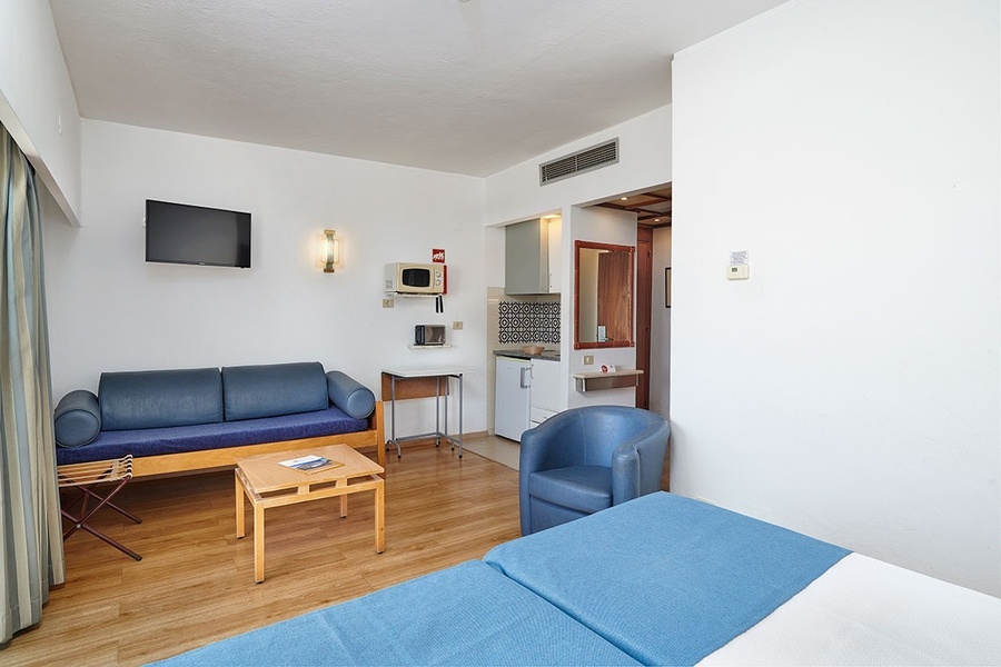 uma sala de estar com um sofá azul e uma cadeira