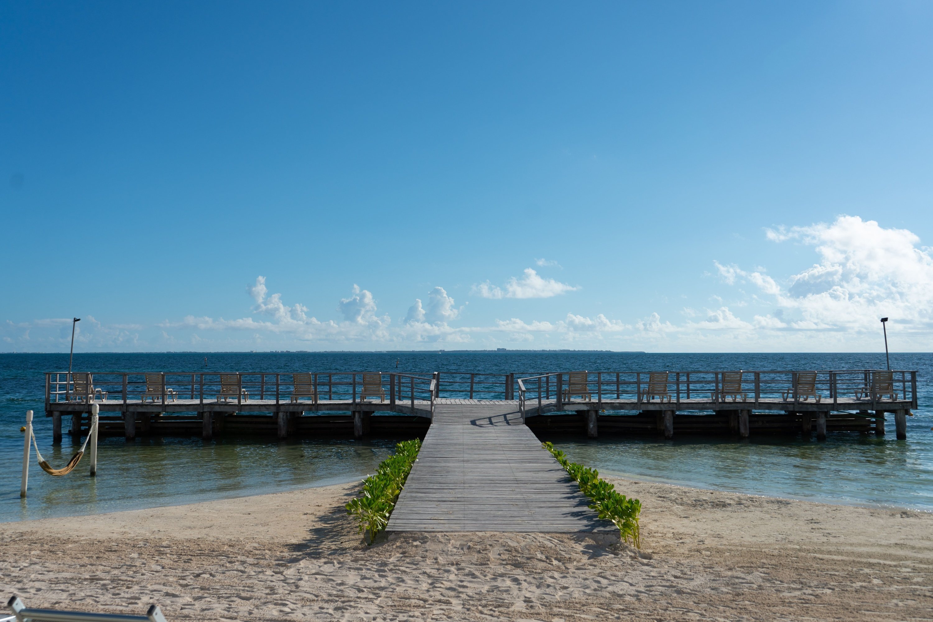 una hamaca y una silla en una playa tropical