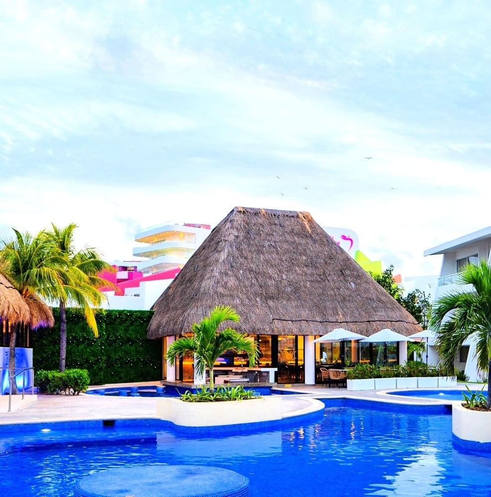 a swimming pool with a thatched roof and a bar