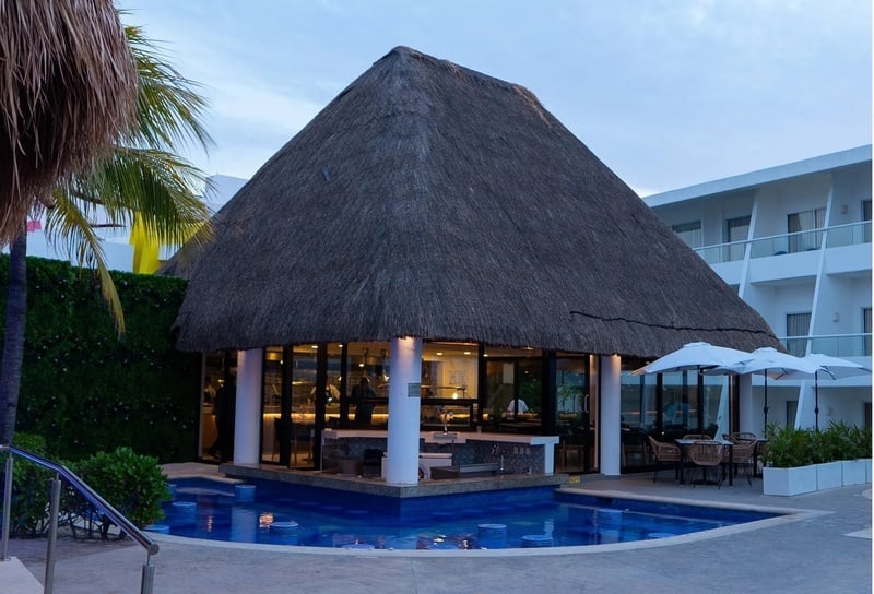 a thatched building with a swimming pool in front of it