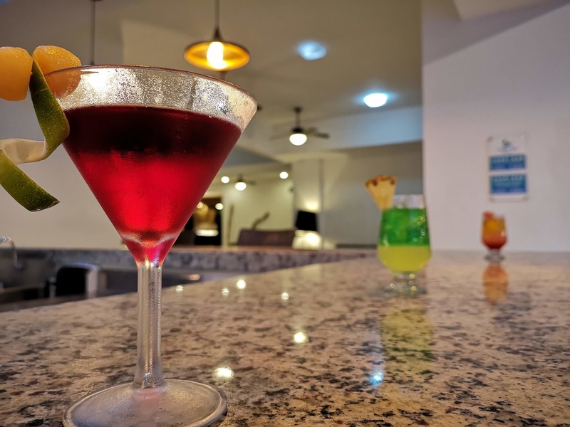 un cóctel rojo en una copa de martini en un bar
