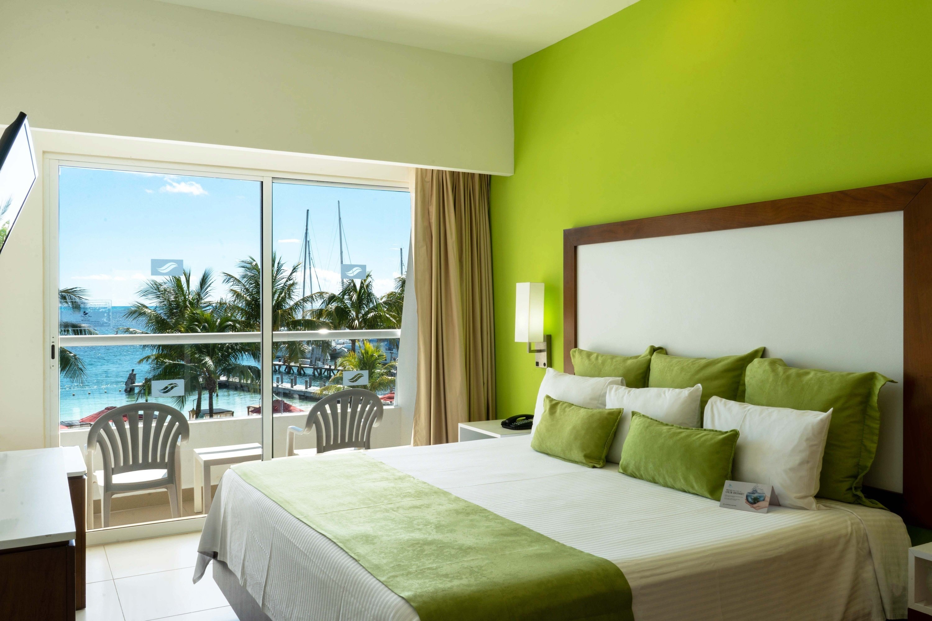 a hotel room with a large bed and green walls