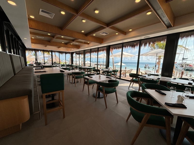 a restaurant with tables and chairs and a view of the ocean