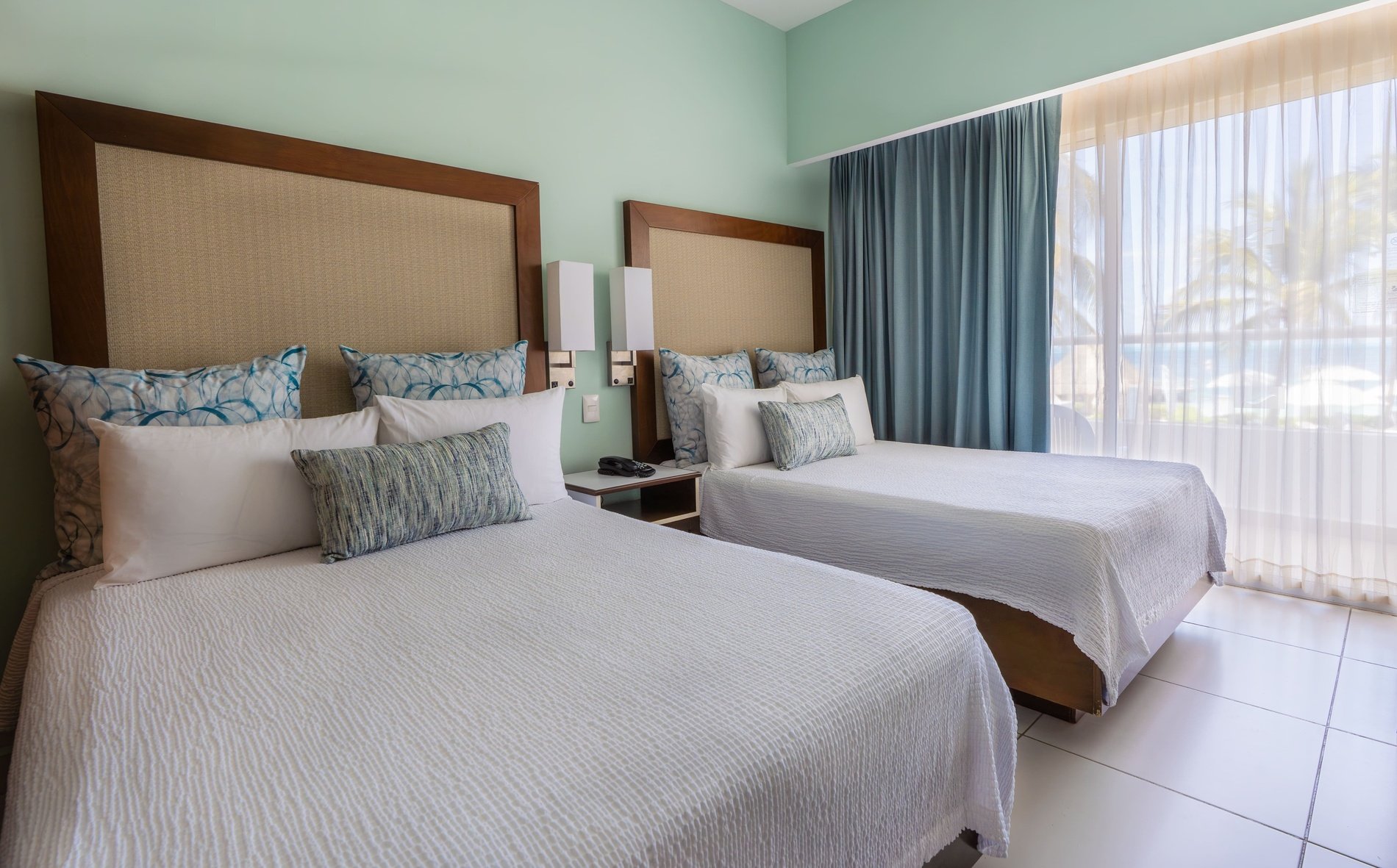 una habitación de hotel con dos camas y una ventana