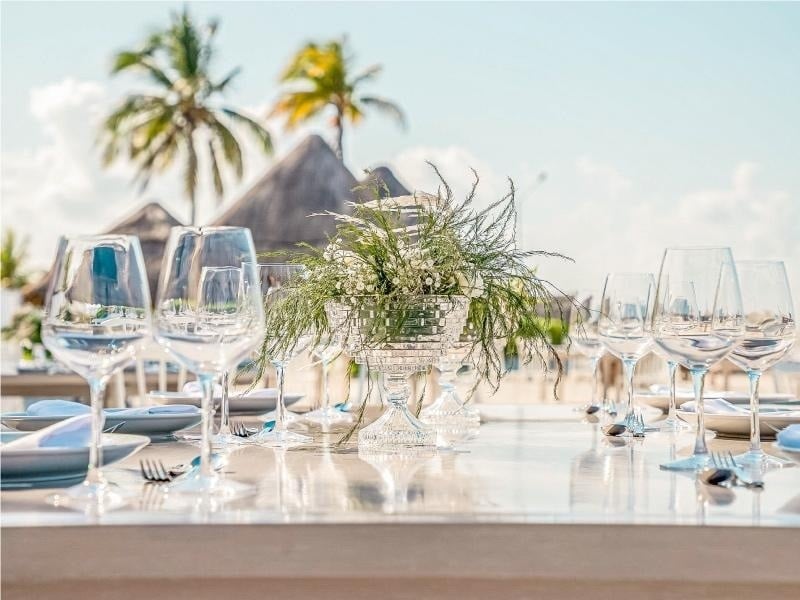 a table with a vase of flowers and wine glasses on it