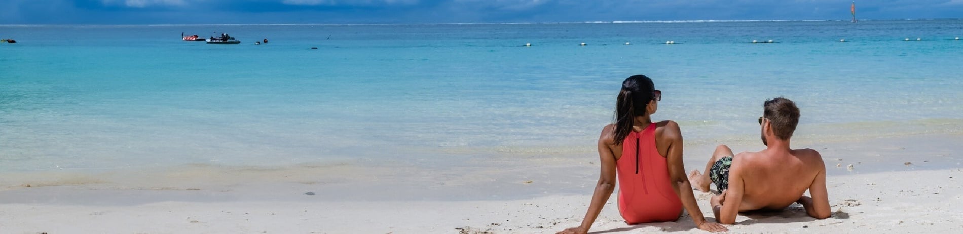 a man is giving a woman a piggyback ride on the beach