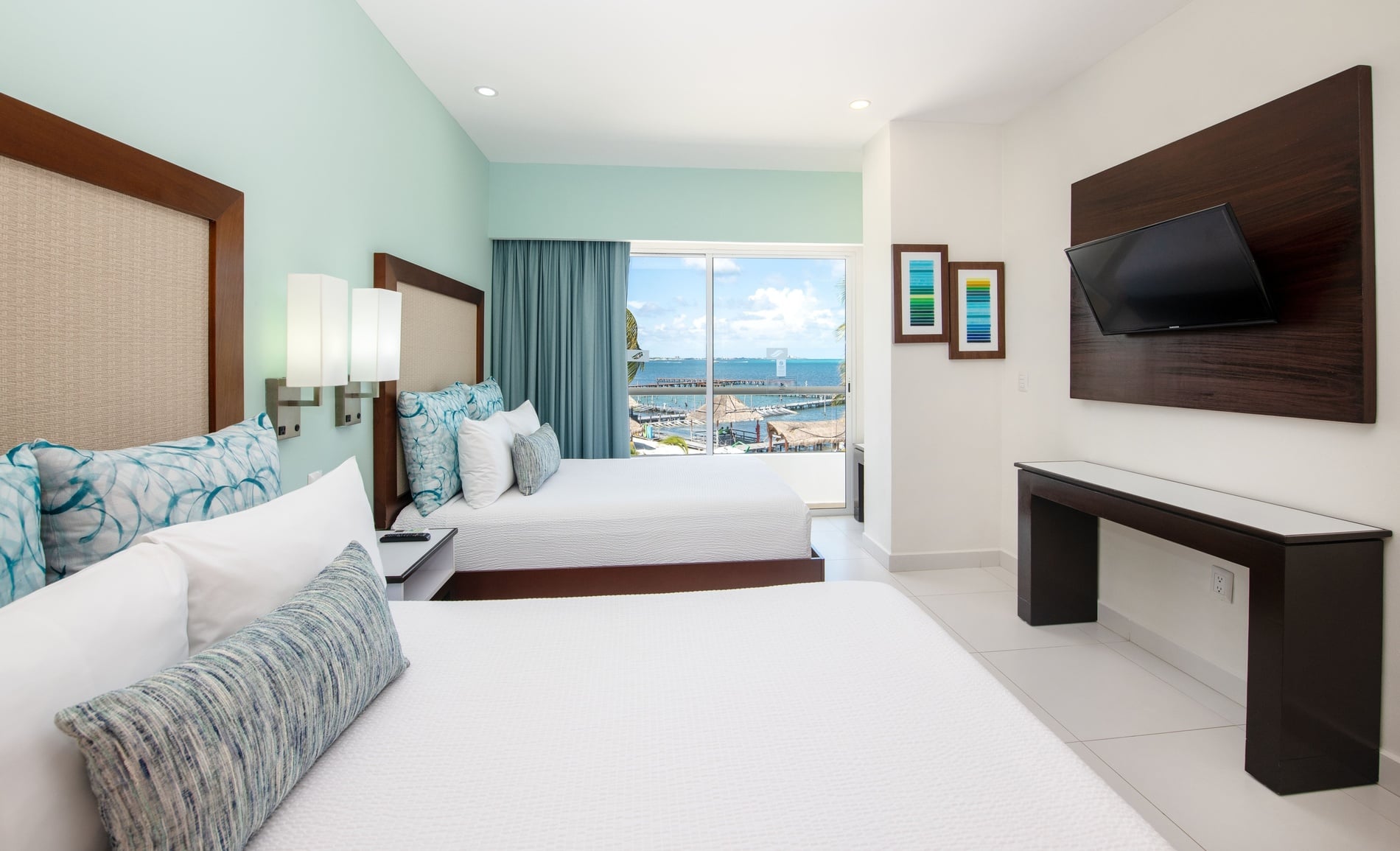 una habitación de hotel con dos camas y una pared verde