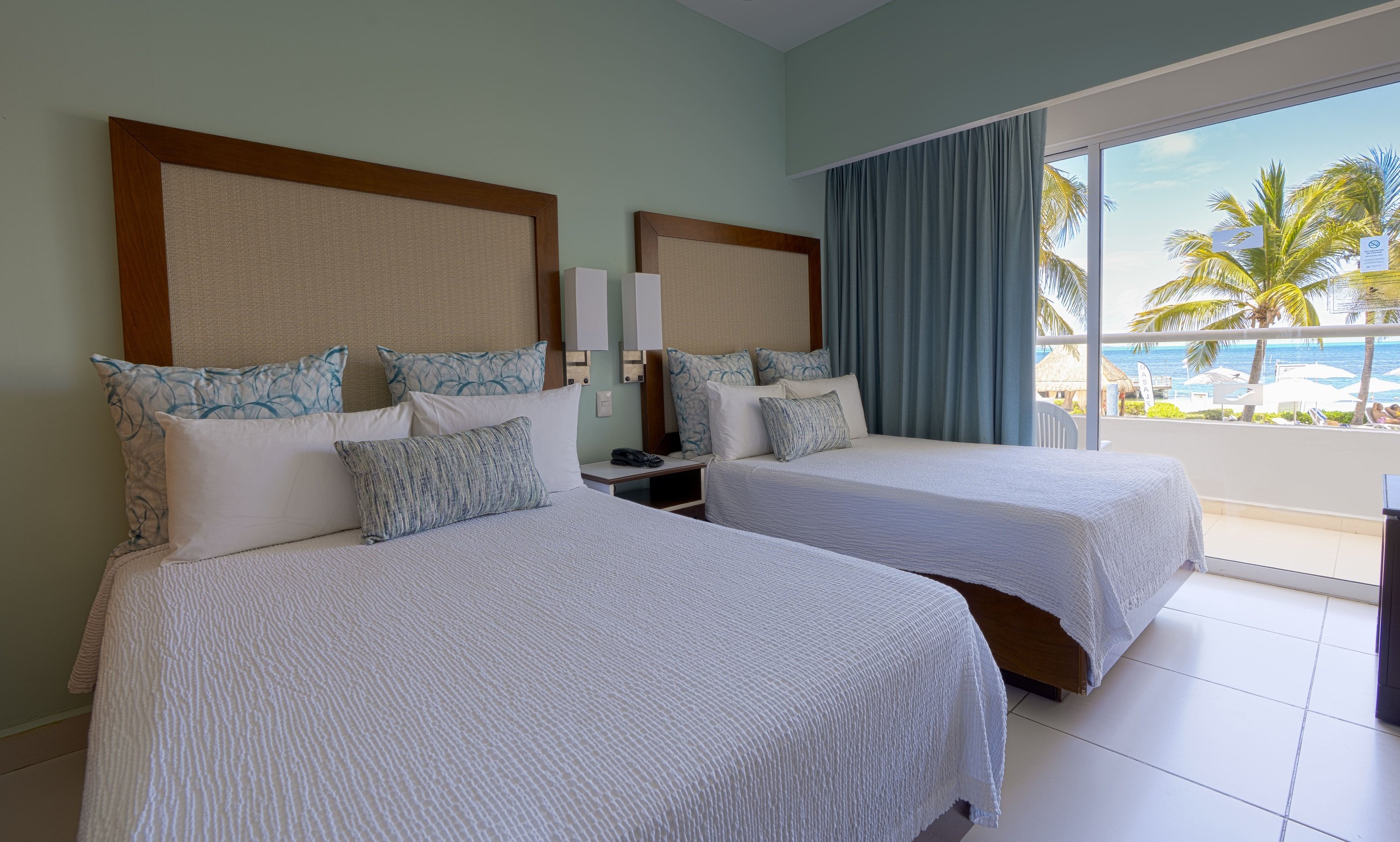 una habitación de hotel con una cama king size y una vista al océano