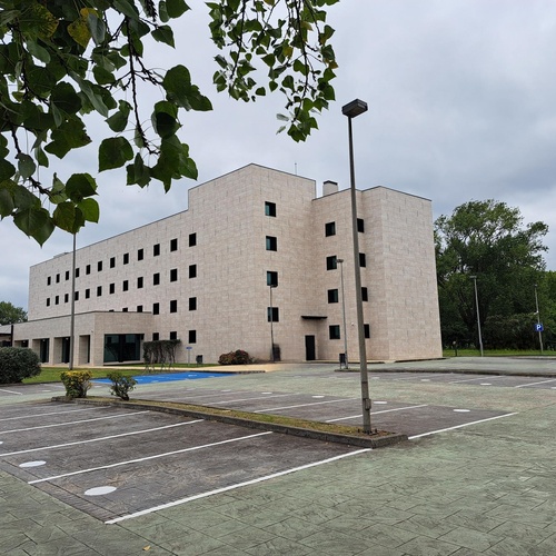 un gran edificio de hormigón con un estacionamiento al frente