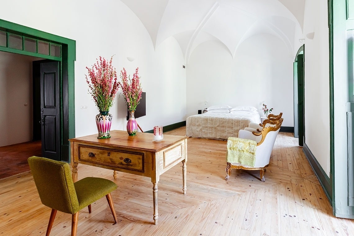 um quarto com uma mesa de madeira e vasos de flores