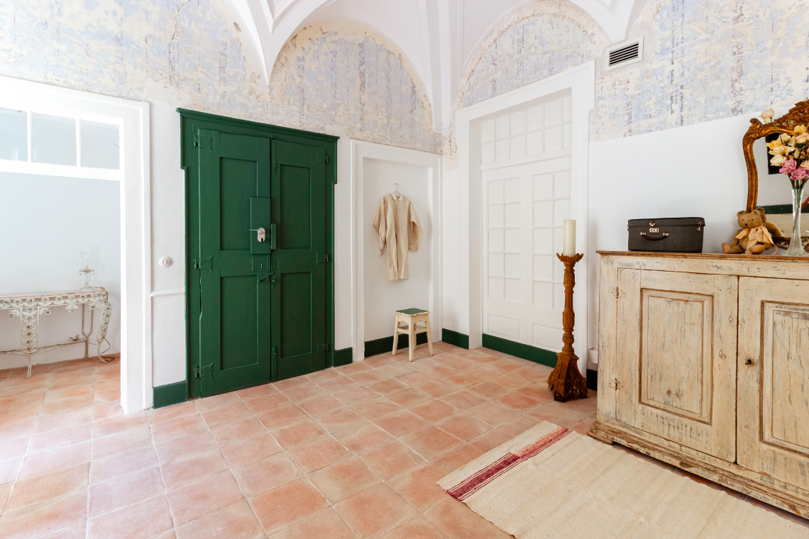 a hallway with green doors and white cabinets