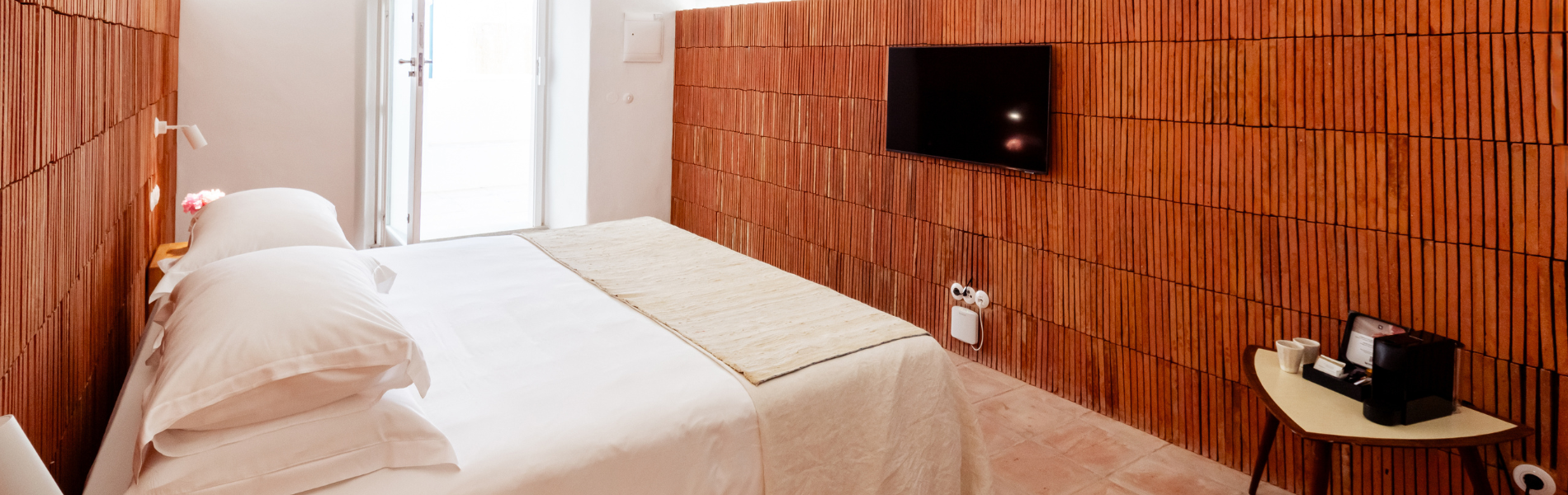 um quarto com uma cama e uma televisão na parede