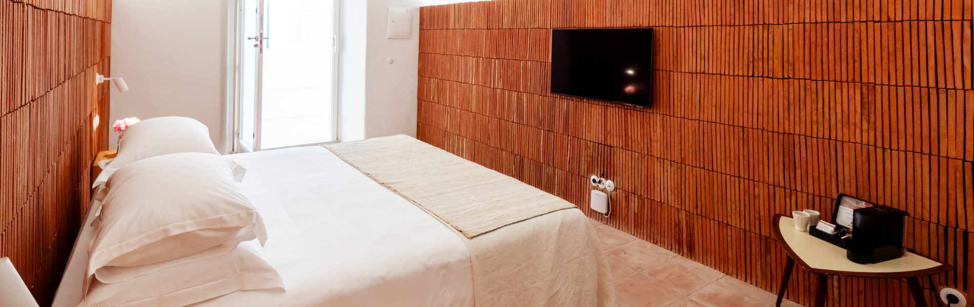 a bedroom with a bed and a television on the wall