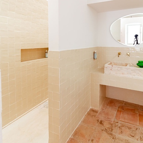 un baño con lavabo y ducha y un espejo