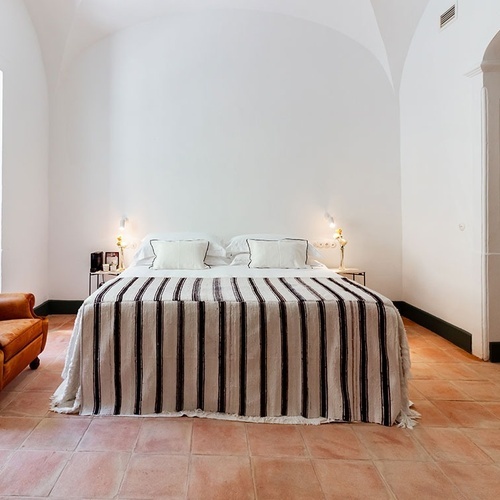un dormitorio con una cama a rayas y una silla