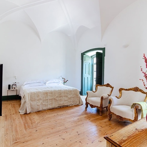 una habitación con una cama y dos sillas y una televisión