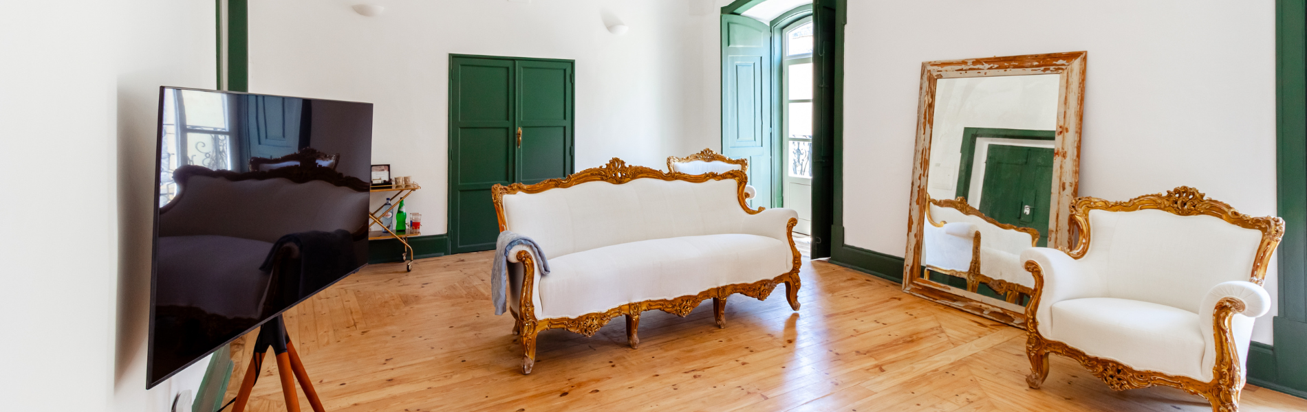 uma sala com sofá e cadeiras e um grande espelho