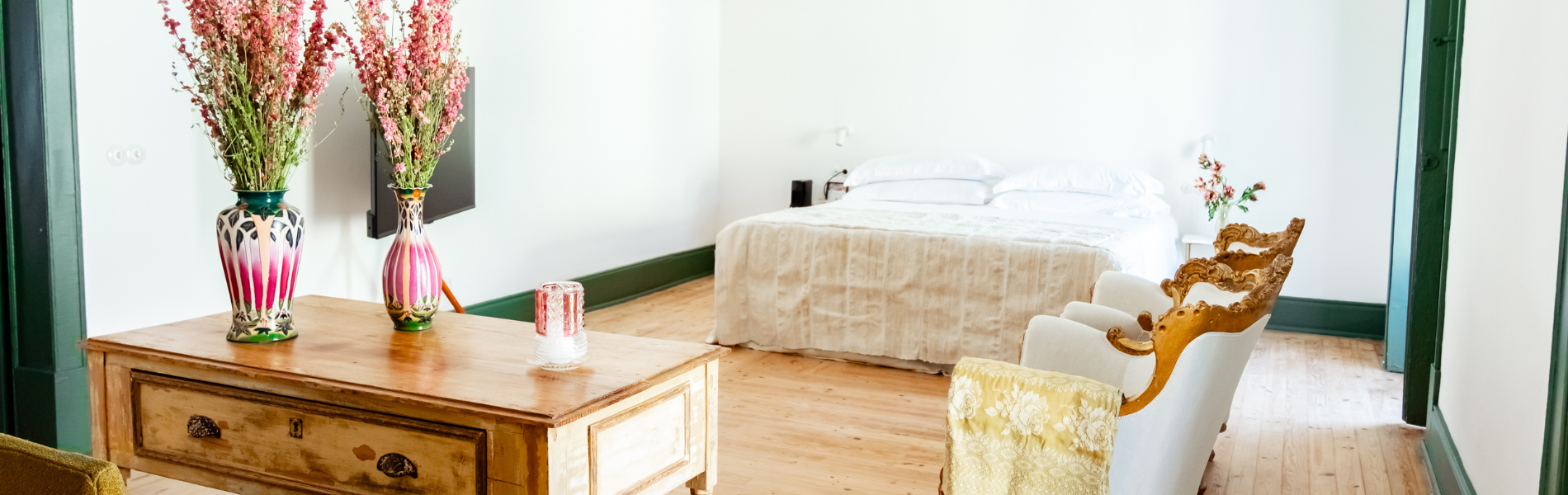 a bedroom with a bed and two vases of flowers