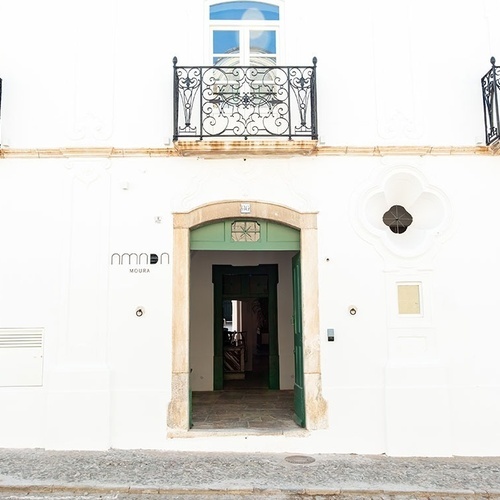 un edificio blanco con una puerta verde y la palabra mira en la parte superior
