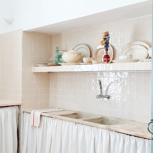 una cocina con platos y vasos en los estantes