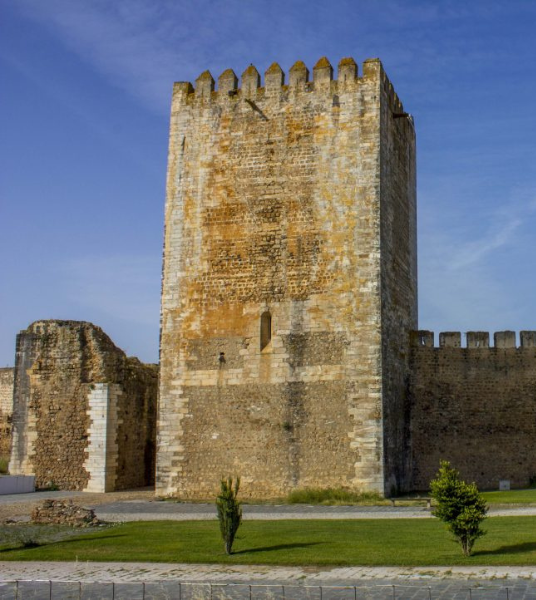 a large stone tower with a blue sky in the background