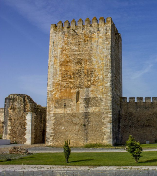 uma grande torre de pedra com um céu azul ao fundo