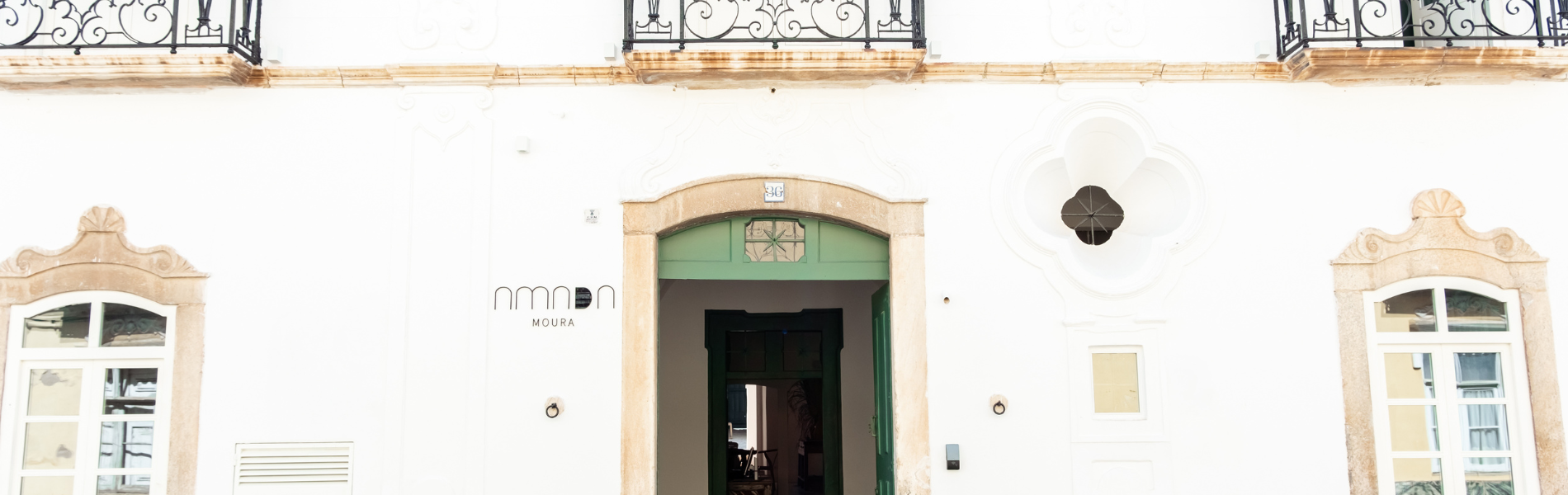 um prédio branco com uma porta verde e o número 48