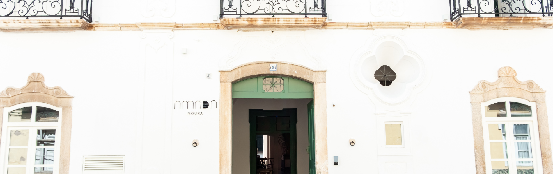 un edificio blanco con una puerta verde y la palabra nova en la parte superior