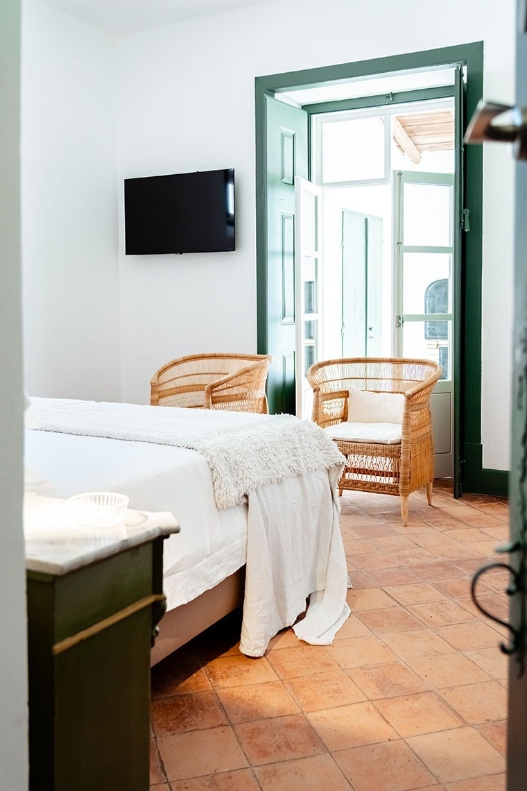 a bedroom with two chairs and a flat screen tv