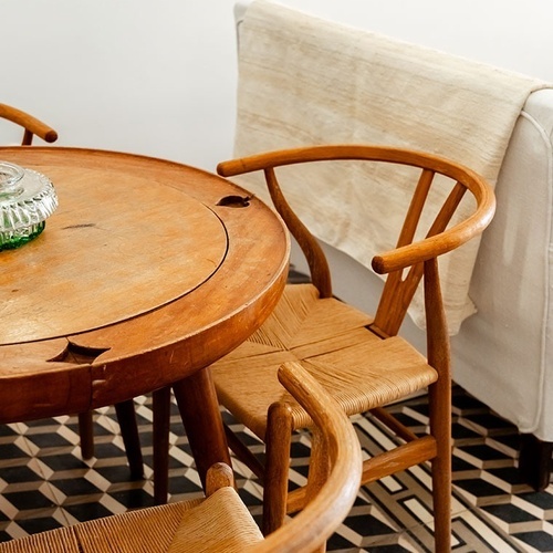 una mesa de madera con dos sillas de mimbre alrededor de ella