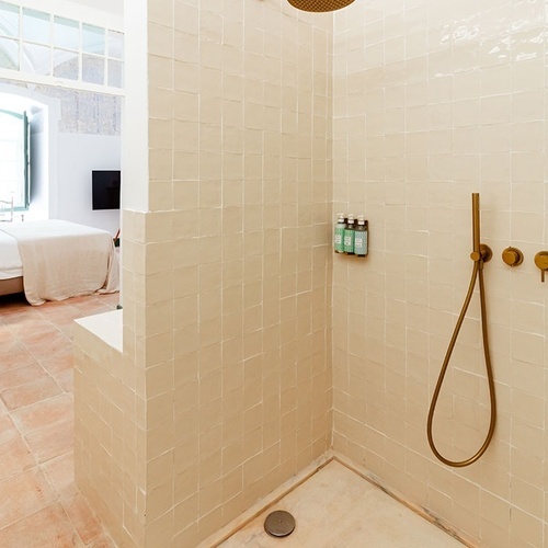 un baño con una ducha y dos botellas de champú