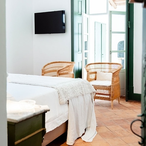 una habitación con una cama y una televisión en la pared
