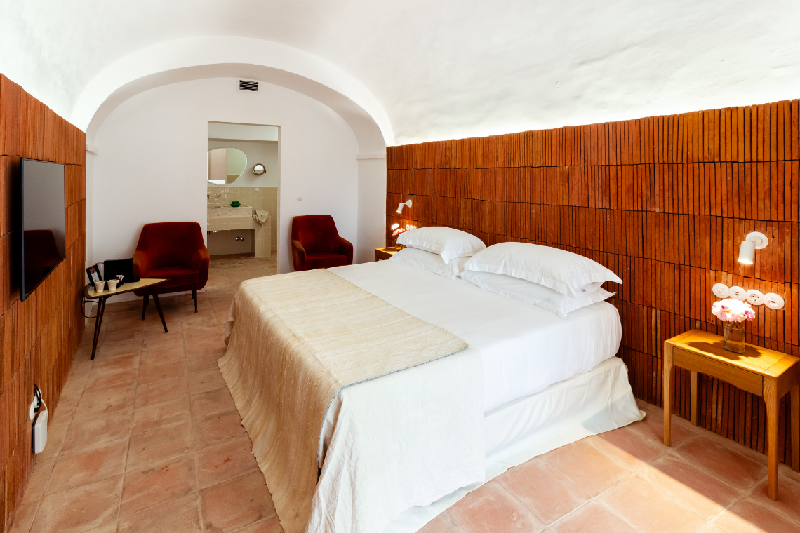 una habitación con una cama y una televisión en la pared