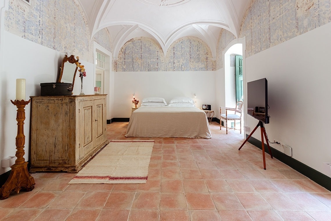 a bedroom with arched ceilings and a flat screen tv