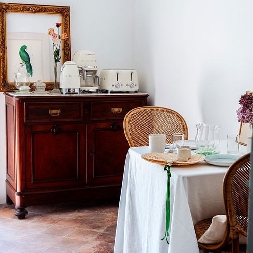 una habitación con una mesa y sillas y una tostadora