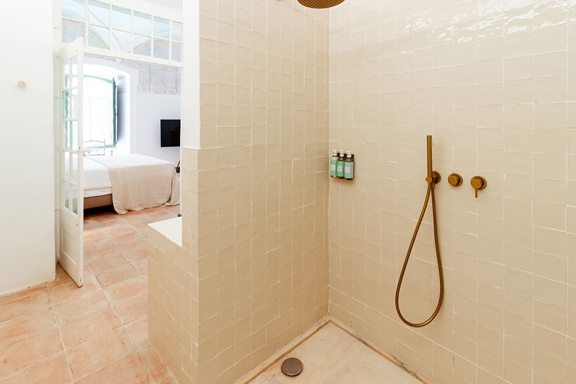 a bathroom with a shower and two bottles of shampoo on the wall