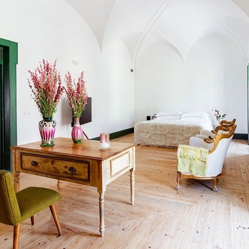 um quarto com uma mesa de madeira e vasos de flores