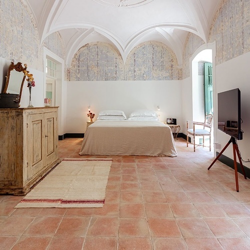 un dormitorio con una cama y una televisión en un trípode