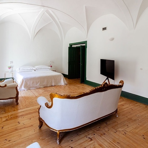 una habitación con una cama y un sofá y una televisión
