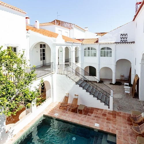 una piscina en un patio entre dos edificios blancos