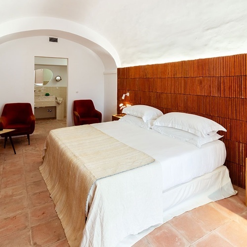 una habitación con una cama y una televisión en la pared